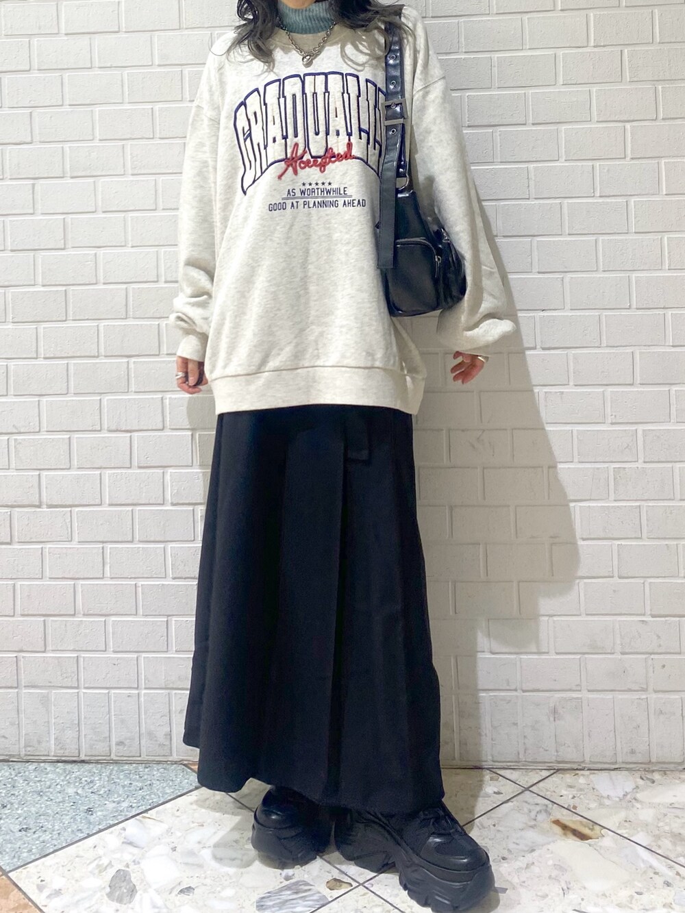 ブラック系のスニーカー、ブラック系のスカート、ベージュ系のスウェットを着用したレディースの冬コーディネートの7枚目の写真