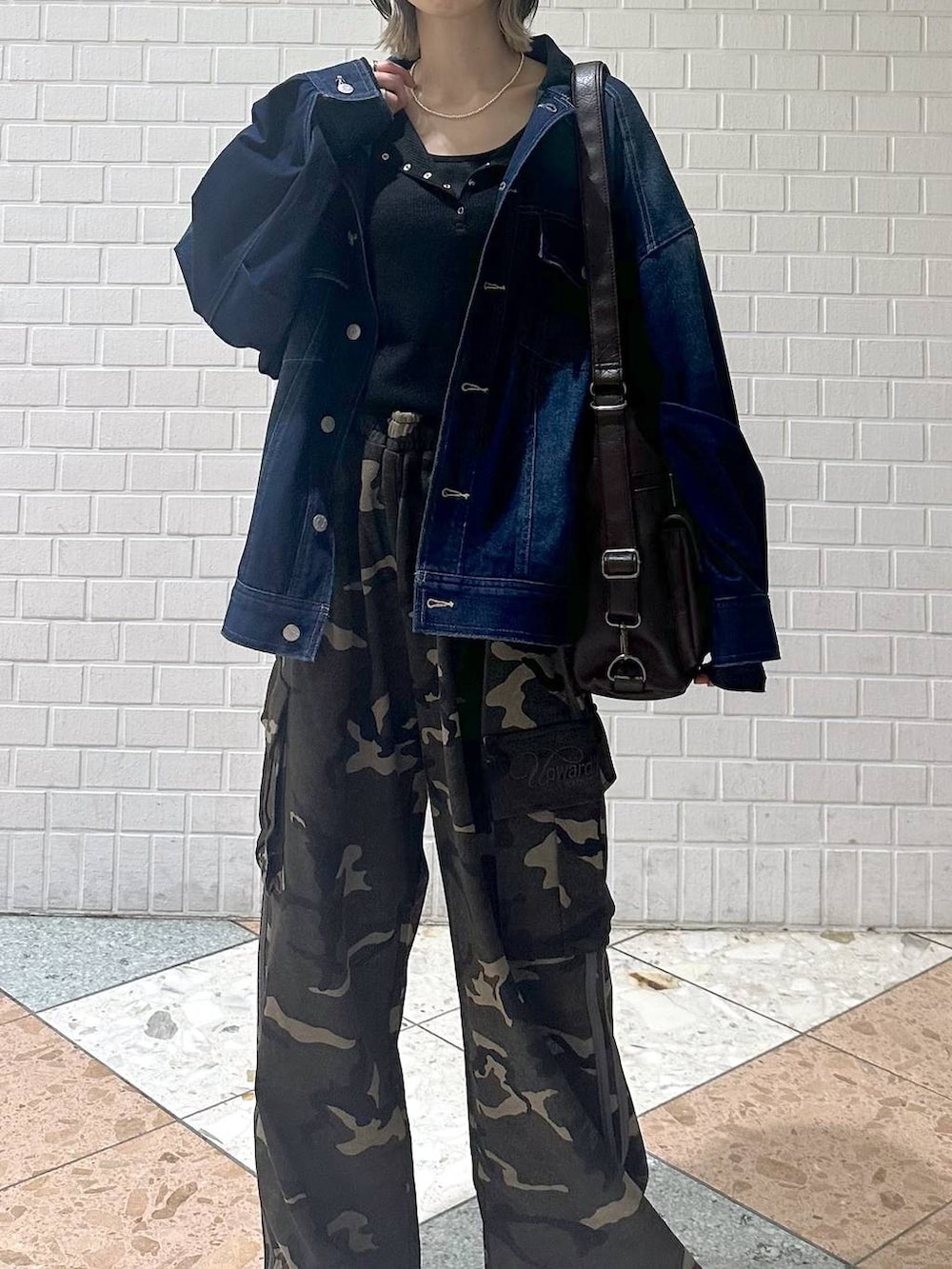 ブラウン系のブーツ、ブラック系のキャミソール、ブルー系のブルゾンを着用したレディースの春コーディネートの9枚目の写真