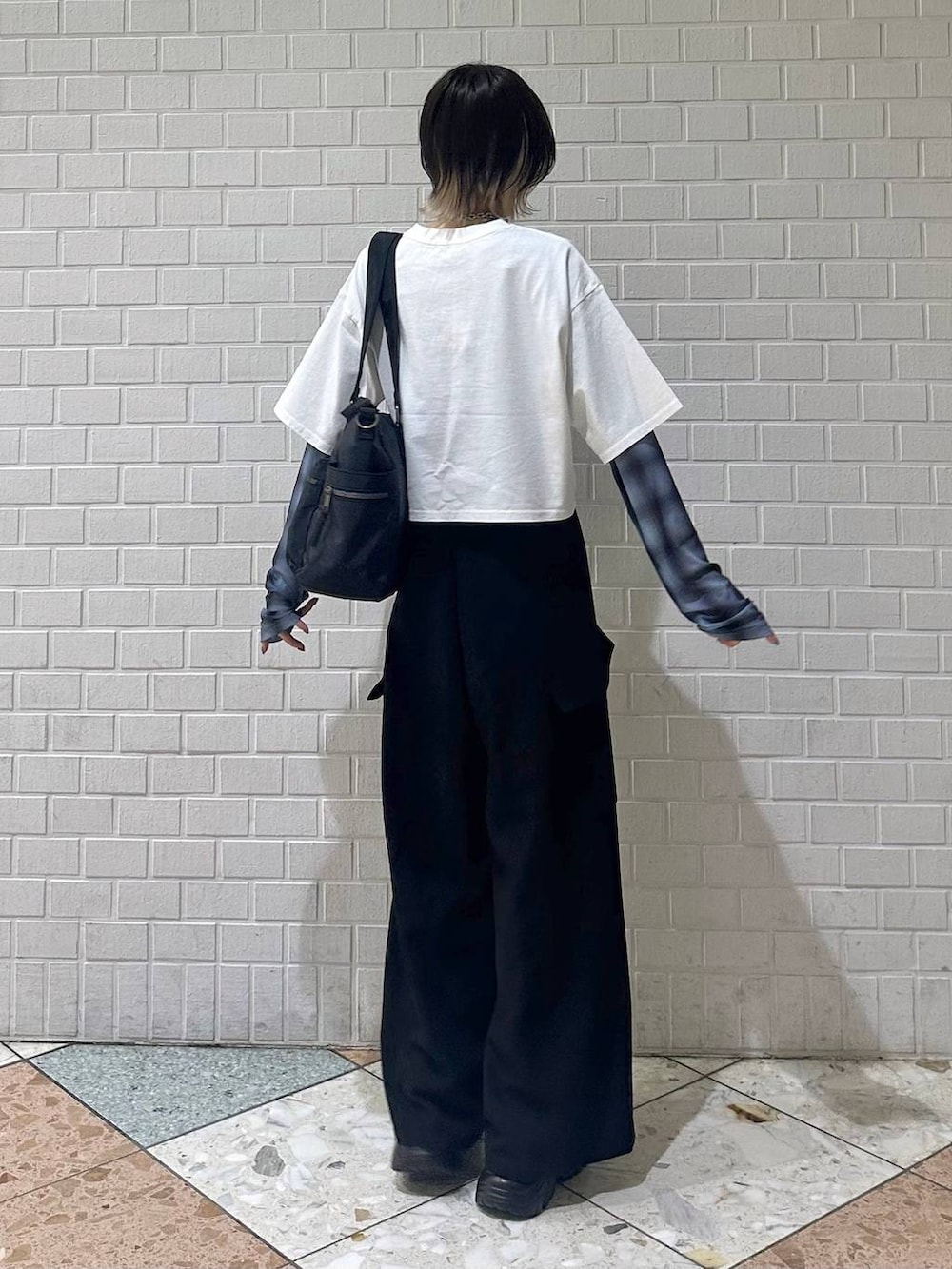 ブラック系のボストンバッグ、ブラック系のサンダル、ホワイト系のTシャツ/カットソーを着用したレディースの春コーディネートの6枚目の写真