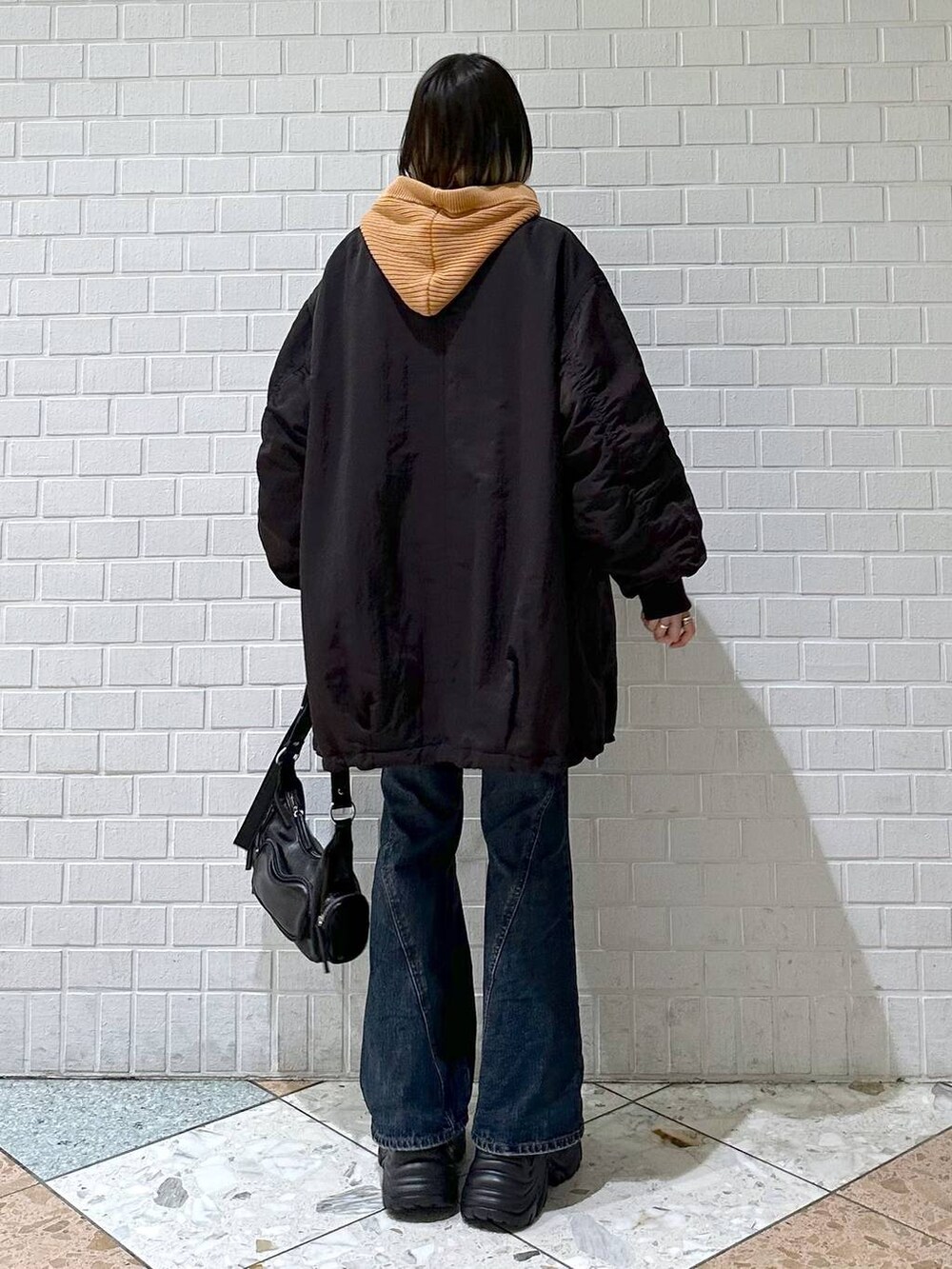 ブラック系のブーツ、ブルー系のデニムパンツ、ブラウン系のブルゾンを着用したレディースの秋コーディネートの6枚目の写真