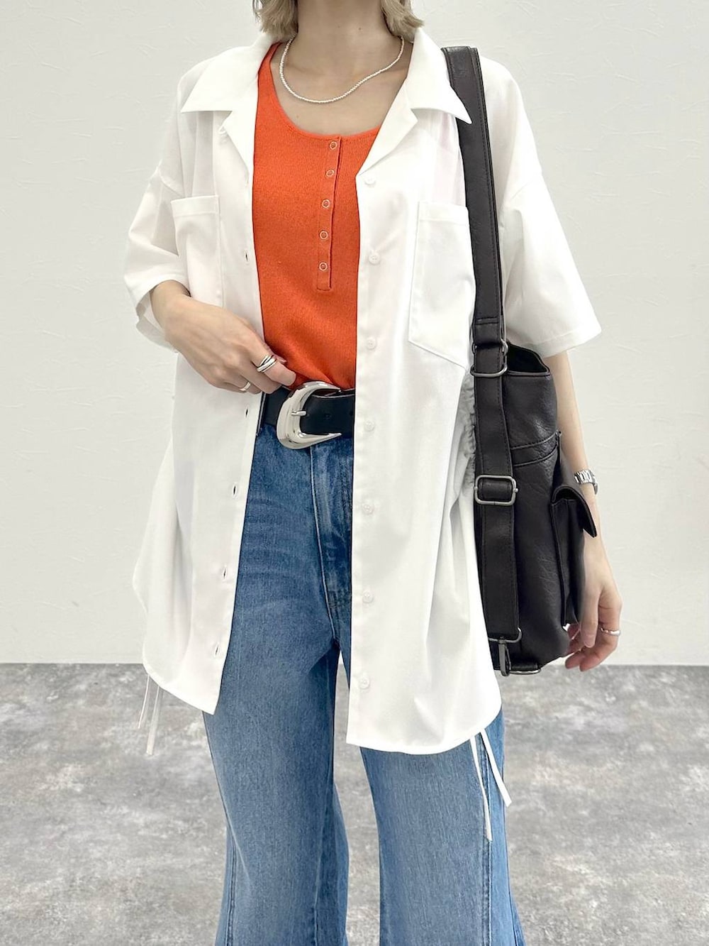 ブルー系のデニムパンツ、ブラック系のショルダーバッグ、グレー系のサンダルを着用したレディースの春コーディネートの9枚目の写真