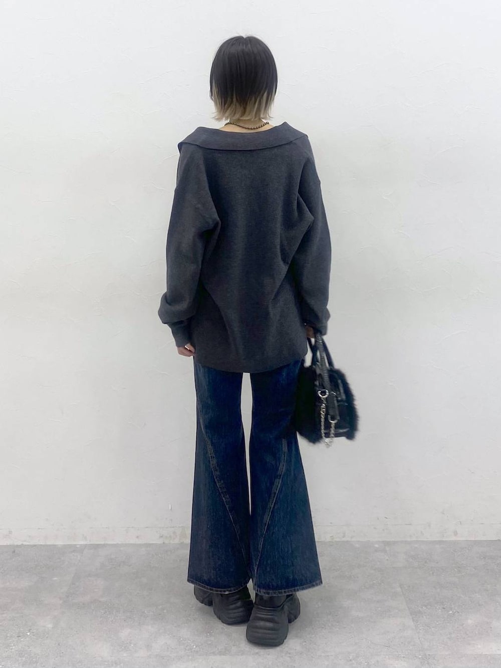 ブラック系のブーツ、ブルー系のデニムパンツ、レッド系のTシャツ/カットソーを着用したレディースの秋コーディネートの6枚目の写真