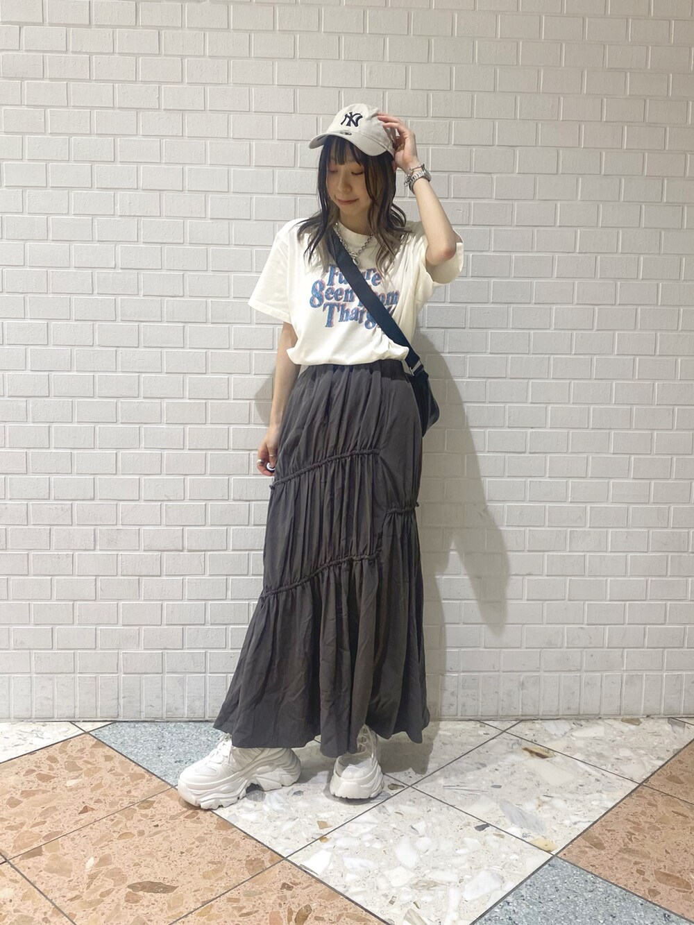 ホワイト系のスニーカー、ブラック系のショルダーバッグ、ベージュ系のTシャツ/カットソーを着用したレディースの夏コーディネートの6枚目の写真