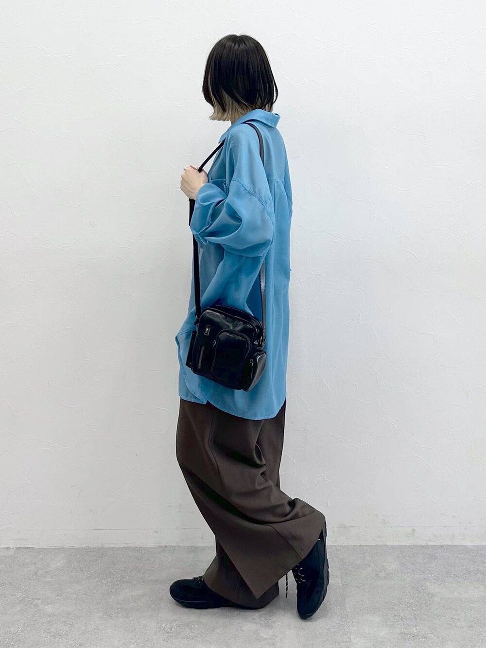 ブラック系のキャミソール、ブラック系のスニーカー、ブラック系のショルダーバッグを着用したレディースの春コーディネートの5枚目の写真