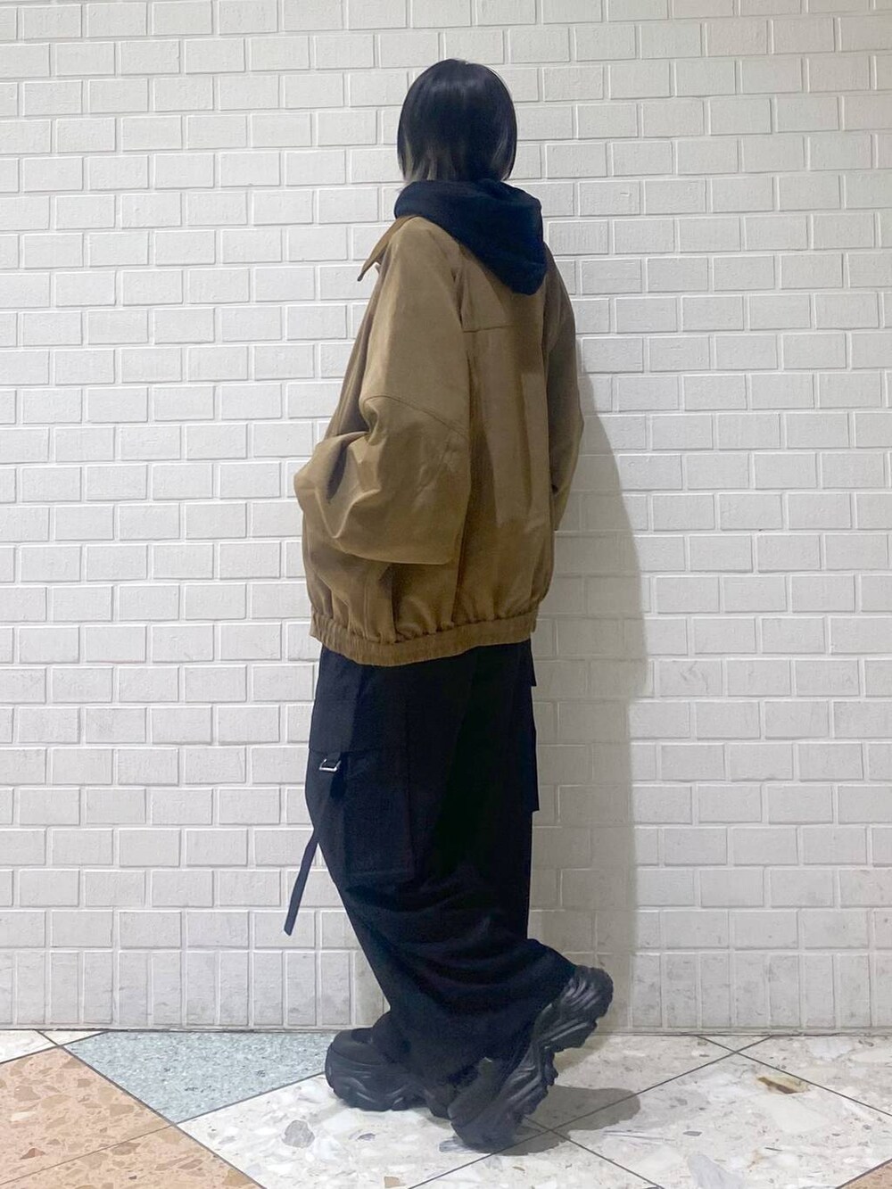 ブラック系のブーツ、ブラック系のパーカー、ベージュ系のブルゾンを着用したレディースの秋コーディネートの6枚目の写真