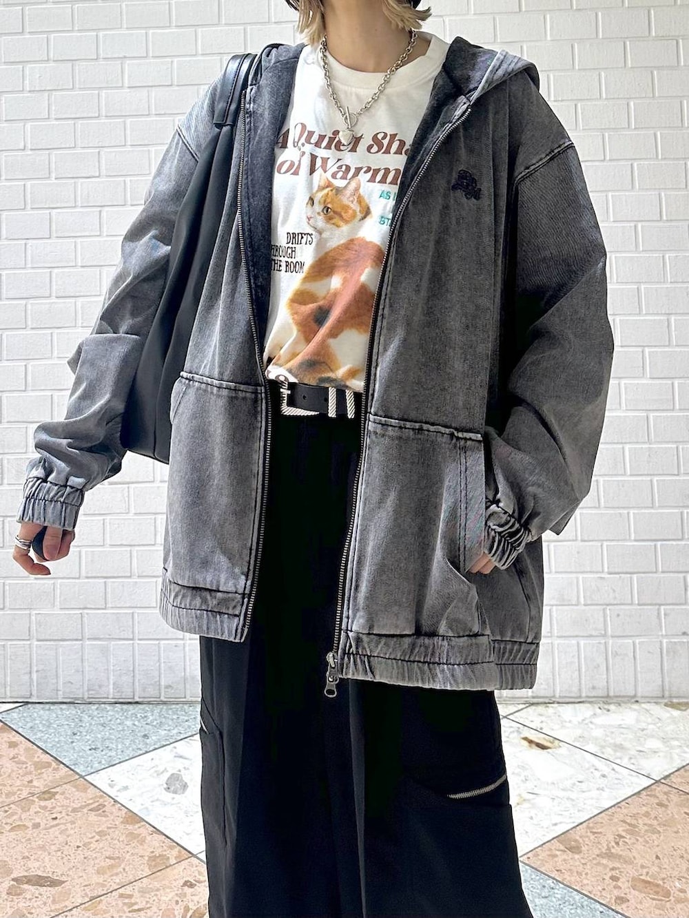 ホワイト系のスニーカー、ブラック系のスラックス、ブラック系のパーカーを着用したレディースの春コーディネートの5枚目の写真