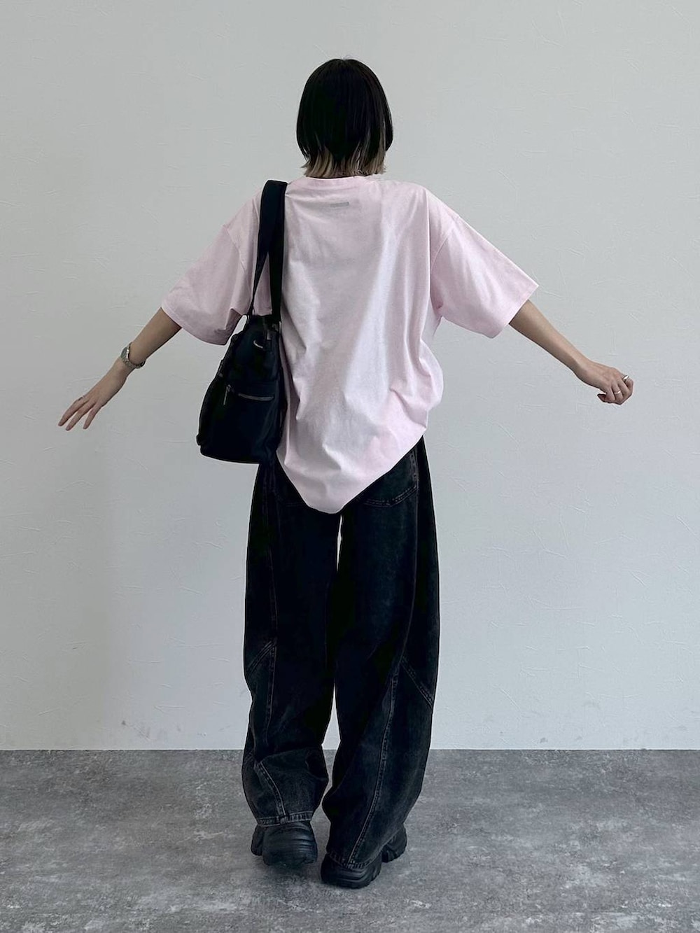 ブラック系のスニーカー、ブラック系のボストンバッグ、ブラック系のデニムパンツを着用したレディースの春コーディネートの6枚目の写真