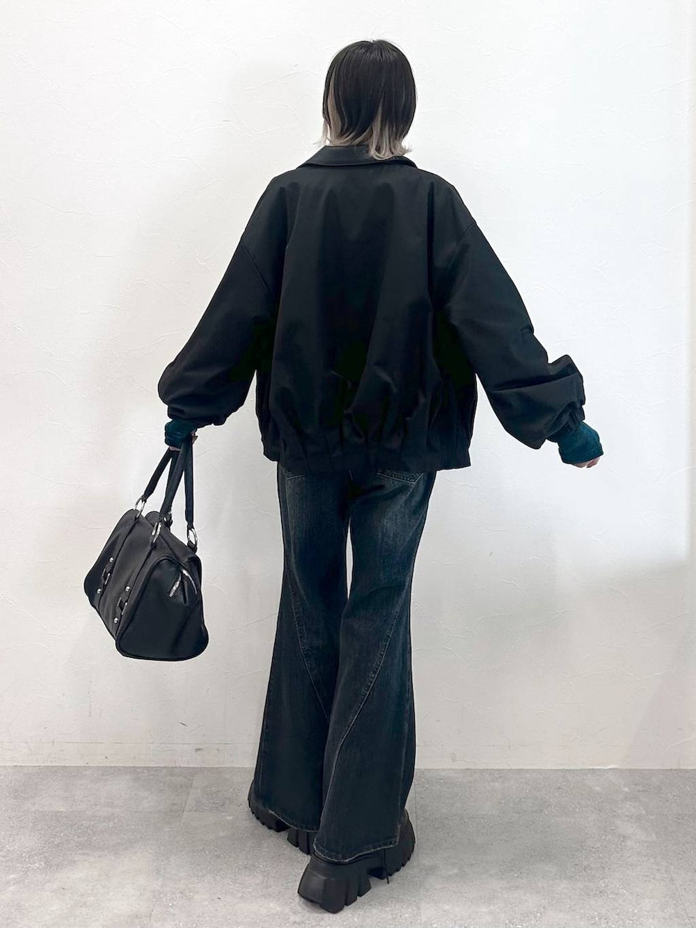 ブラック系のブーツ、ブラック系のボストンバッグ、ブルー系のTシャツ/カットソーを着用したレディースの秋コーディネートの6枚目の写真