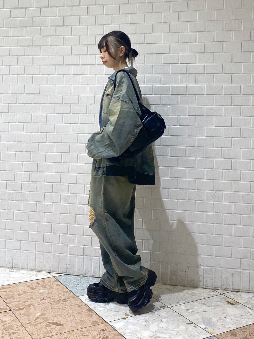 ブラック系のブーツ、ブルー系のデニムパンツ、ホワイト系のTシャツ/カットソーを着用したレディースの秋コーディネートの3枚目の写真