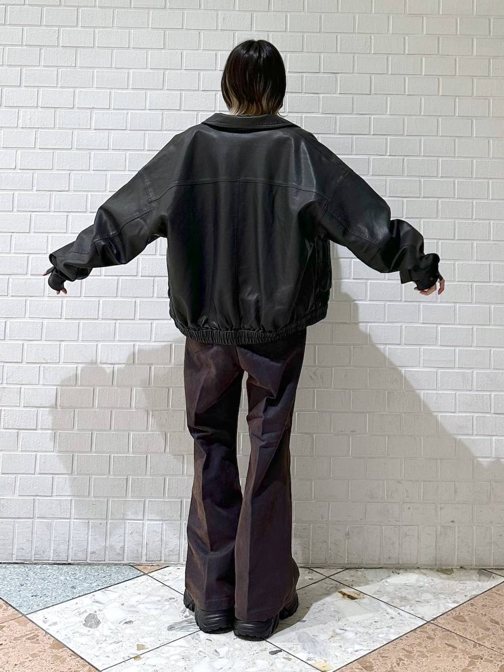 ブラック系のブーツ、ブラック系のブルゾン、ブルー系のデニムパンツを着用したレディースの冬コーディネートの5枚目の写真