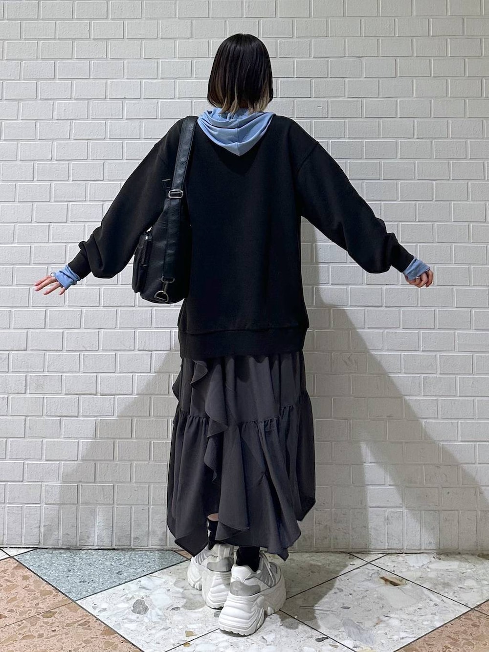 ホワイト系のスニーカー、グレー系のスカート、グレー系のスウェットを着用したレディースの冬コーディネートの6枚目の写真