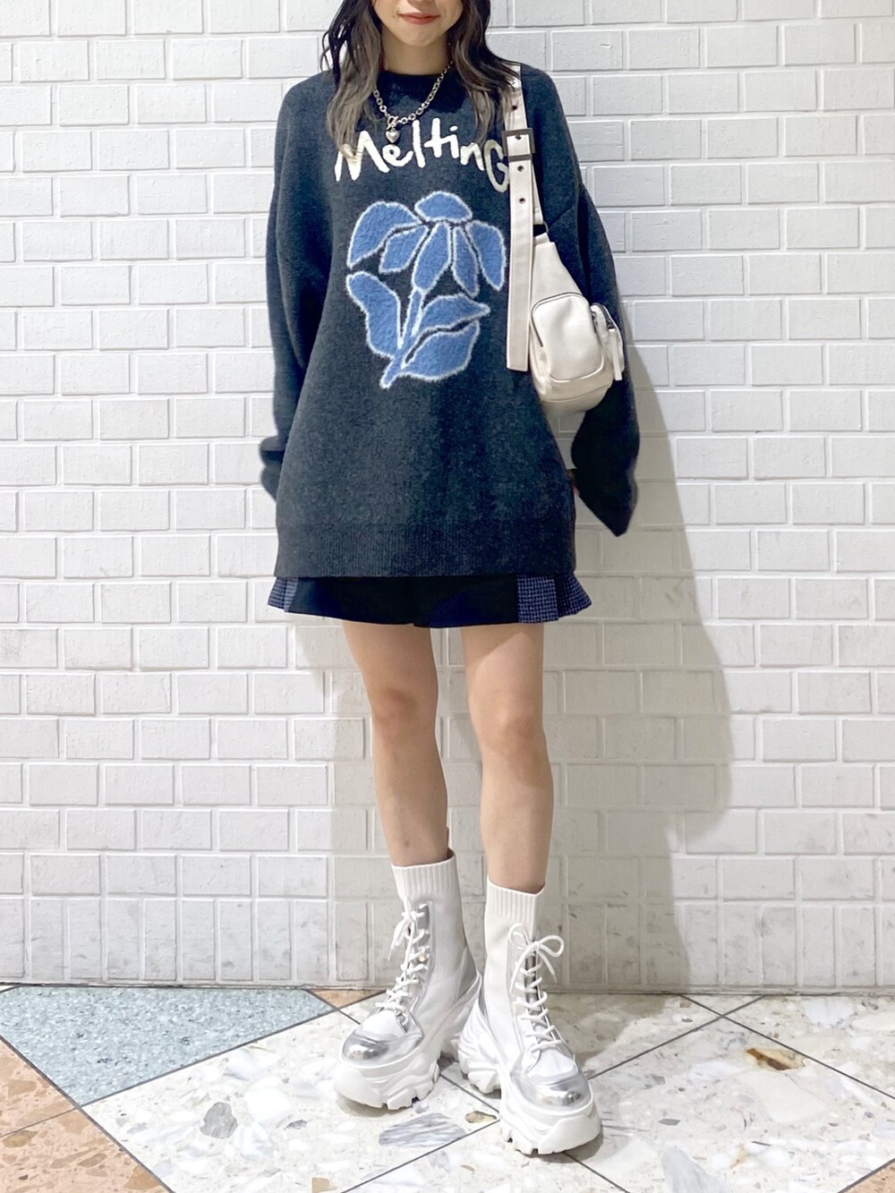 ホワイト系のブーツ、ホワイト系のショルダーバッグ、ブラック系のその他パンツを着用したレディースの秋コーディネートの6枚目の写真