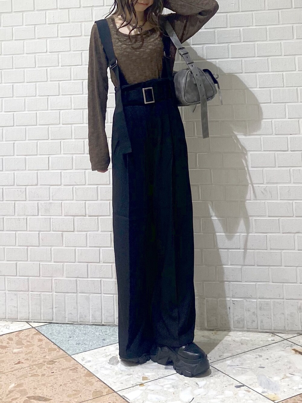 ブラック系のブーツ、ブラック系のスラックス、ブラウン系のTシャツ/カットソーを着用したレディースの秋コーディネートの2枚目の写真