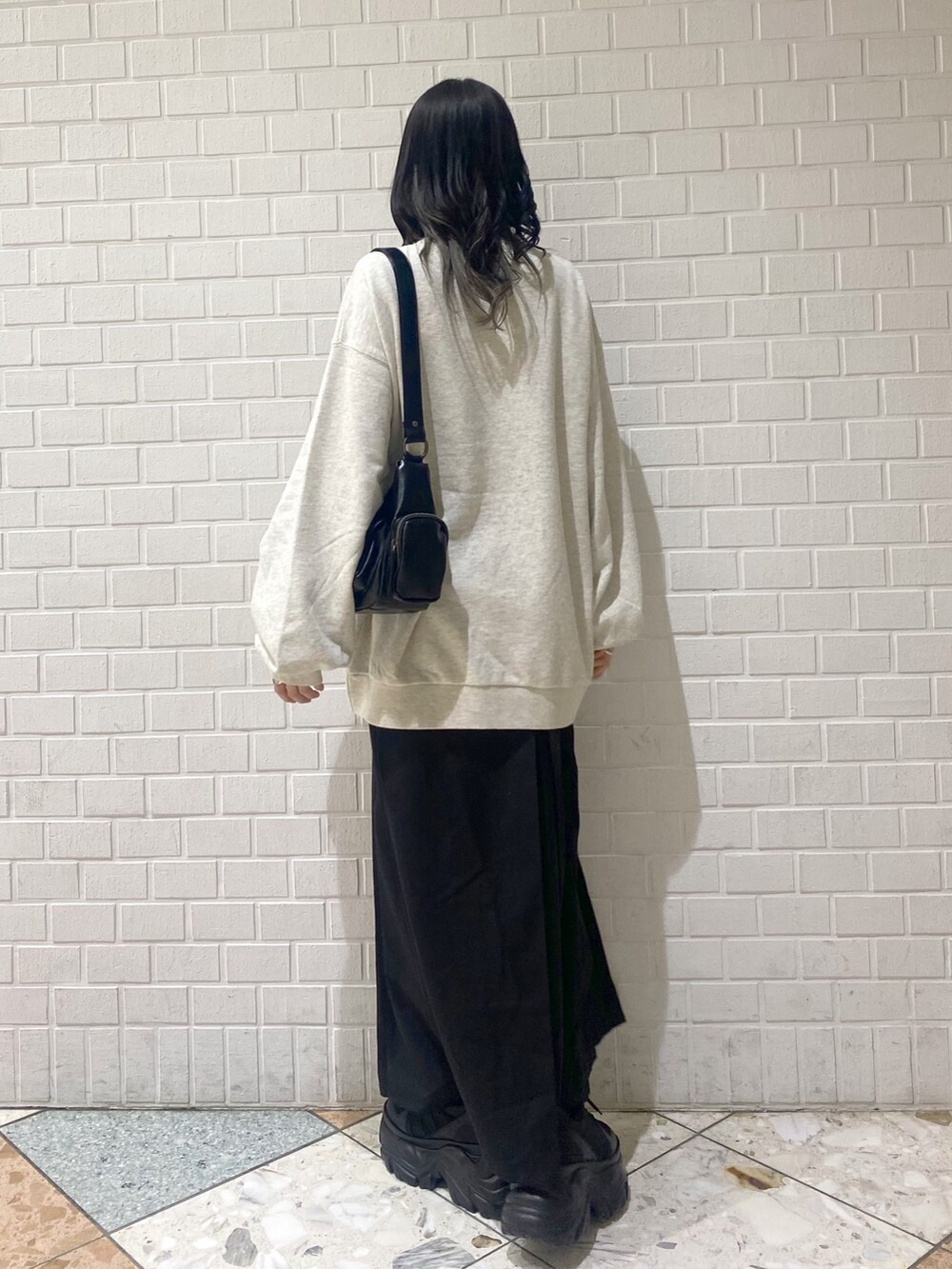 ブラック系のスニーカー、ブラック系のスカート、ベージュ系のスウェットを着用したレディースの冬コーディネートの3枚目の写真