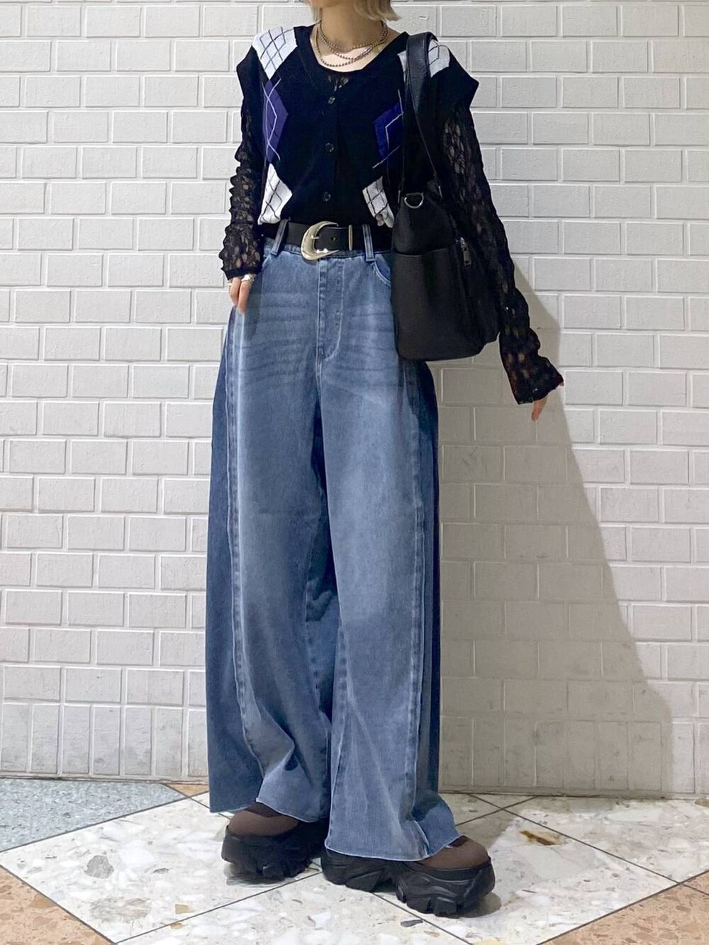 ブラウン系のブーツ、ブルー系のデニムパンツ、ブラック系のボストンバッグを着用したレディースの夏コーディネートの3枚目の写真