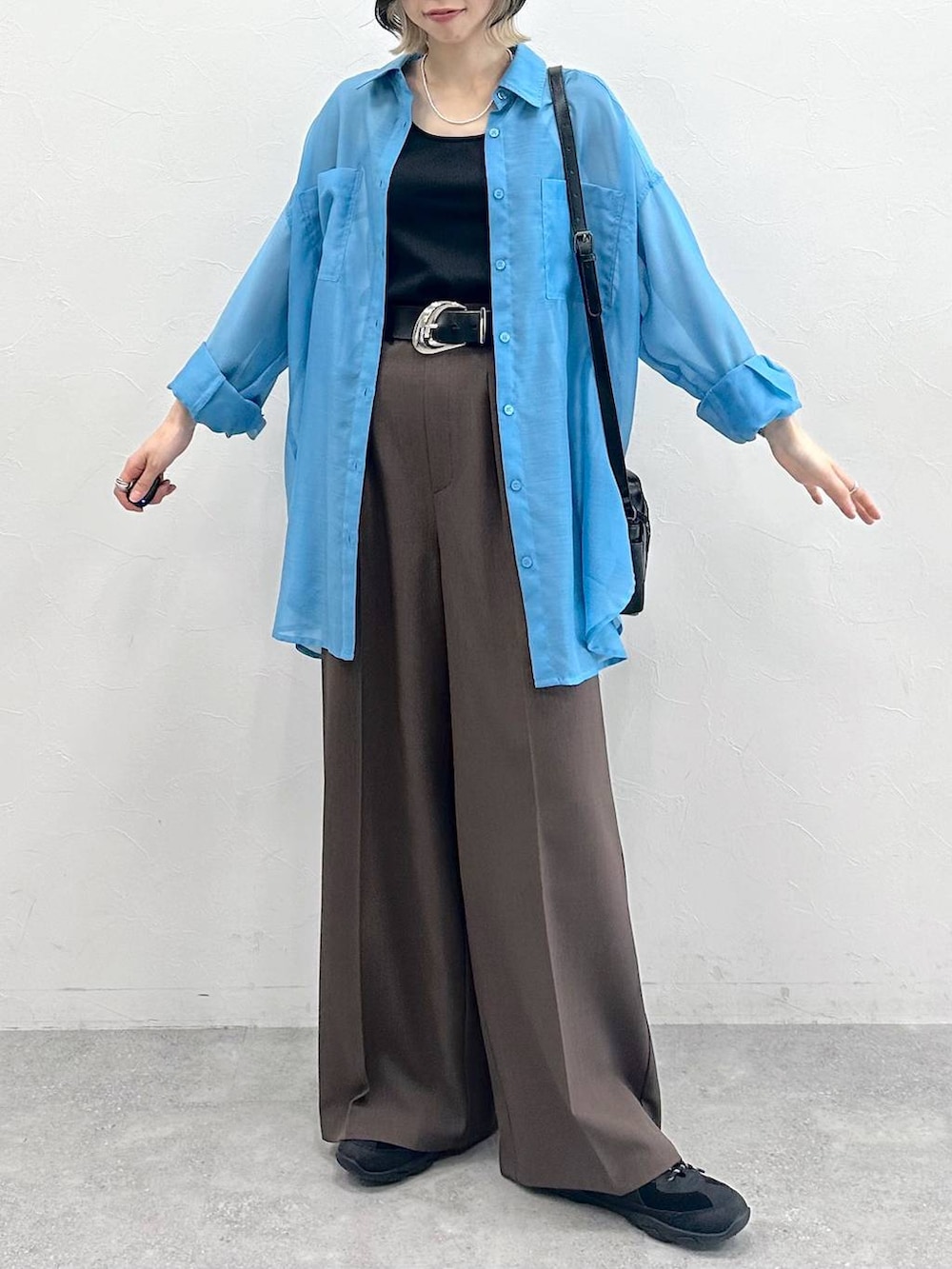 ブラック系のキャミソール、ブラック系のスニーカー、ブラック系のショルダーバッグを着用したレディースの春コーディネートの3枚目の写真