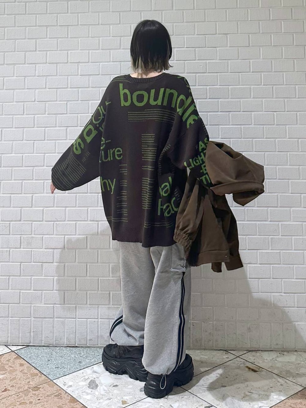 ブラック系のスニーカー、ブラウン系のブルゾン、ブラウン系のニット/セーターを着用したレディースの冬コーディネートの7枚目の写真