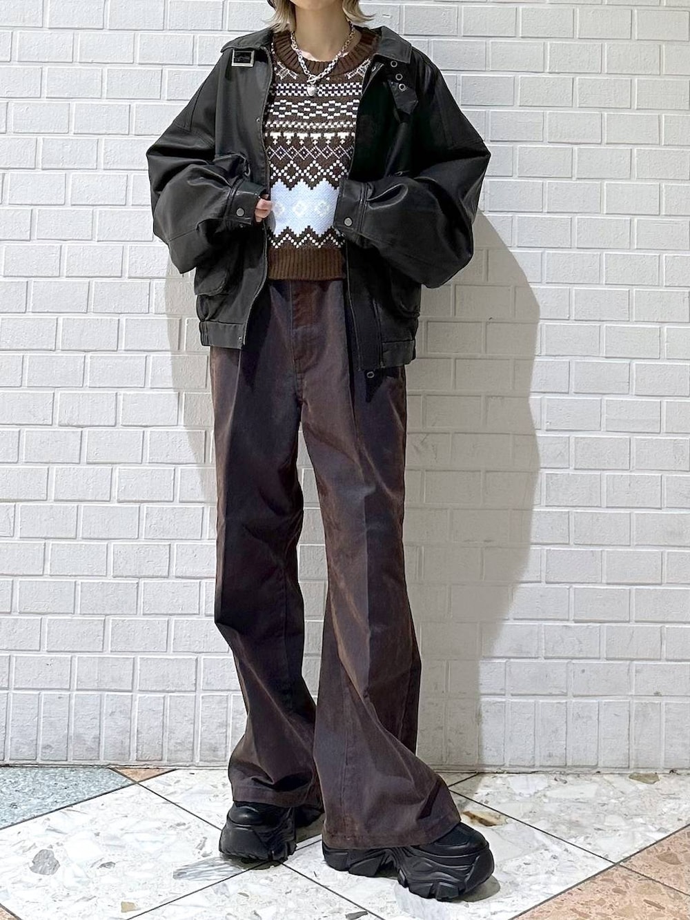 ブラック系のブーツ、ブラック系のブルゾン、ブルー系のデニムパンツを着用したレディースの冬コーディネートの9枚目の写真