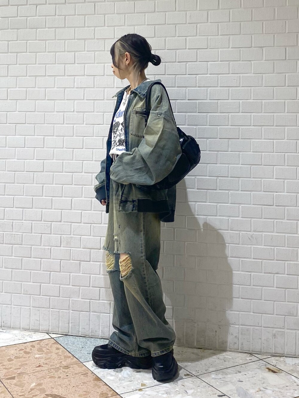 ブラック系のブーツ、ブルー系のデニムパンツ、ホワイト系のTシャツ/カットソーを着用したレディースの秋コーディネートの2枚目の写真