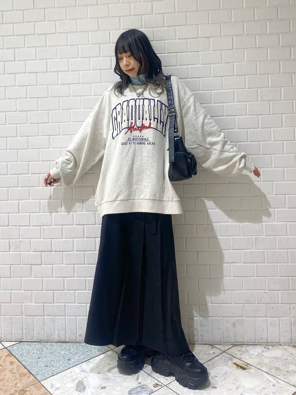 ブラック系のスニーカー、ブラック系のスカート、ベージュ系のスウェットを着用したレディースの冬コーディネートの5枚目の写真