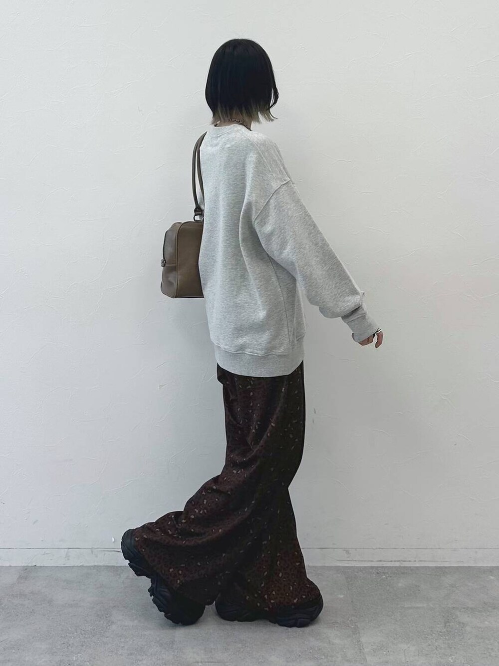 ブラック系のブーツ、ベージュ系のボストンバッグ、グレー系のスウェットを着用したレディースの冬コーディネートの7枚目の写真