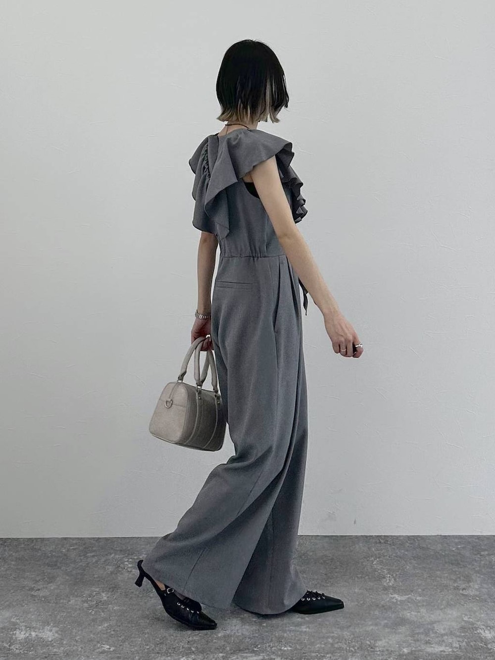 ホワイト系のボストンバッグ、ブラック系のサンダル、グレー系のサロペット/オーバーオールを着用したレディースの春コーディネートの8枚目の写真