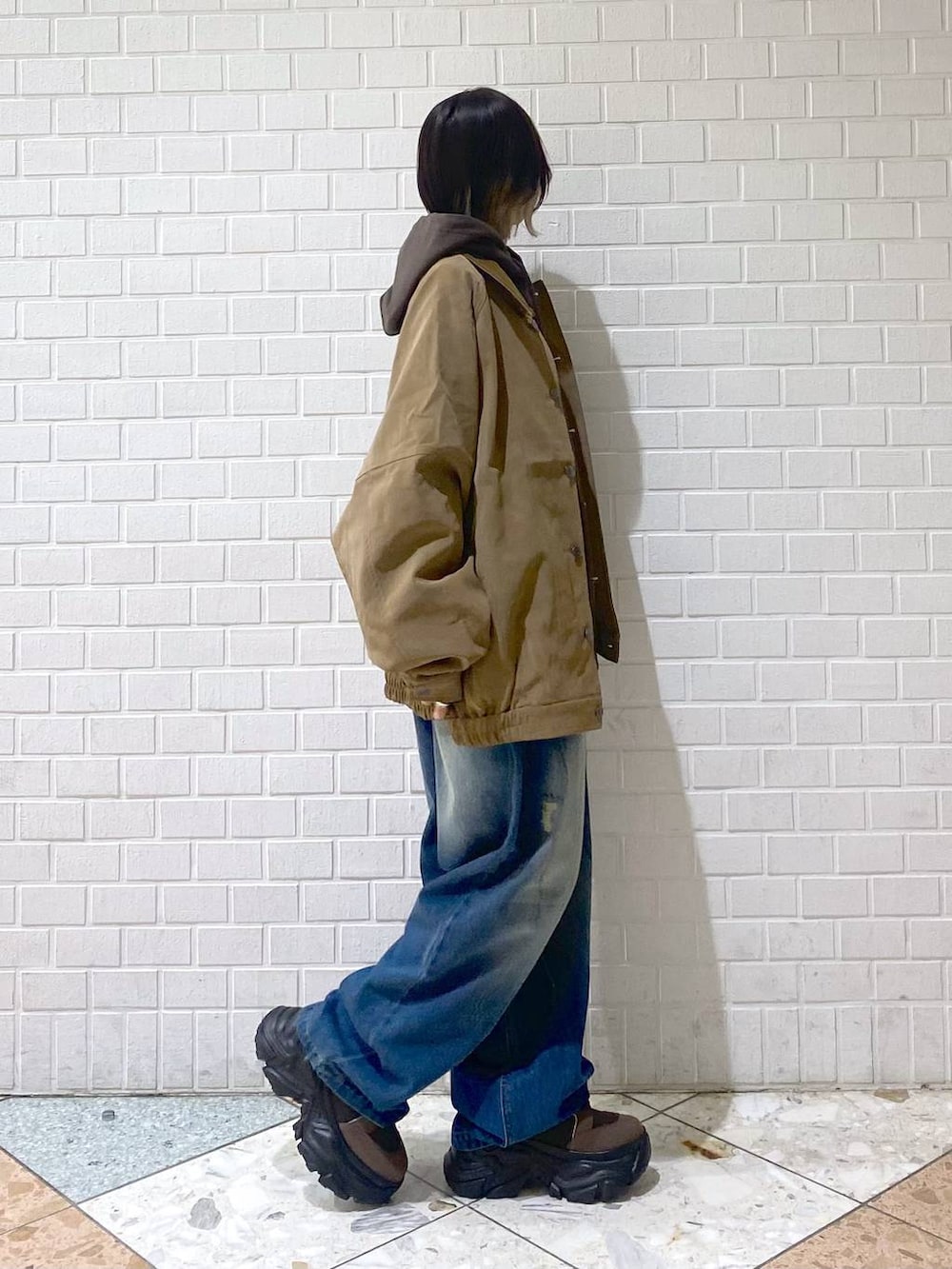 ブラウン系のブーツ、ブルー系のデニムパンツ、ブラウン系のパーカーを着用したレディースの秋コーディネートの8枚目の写真