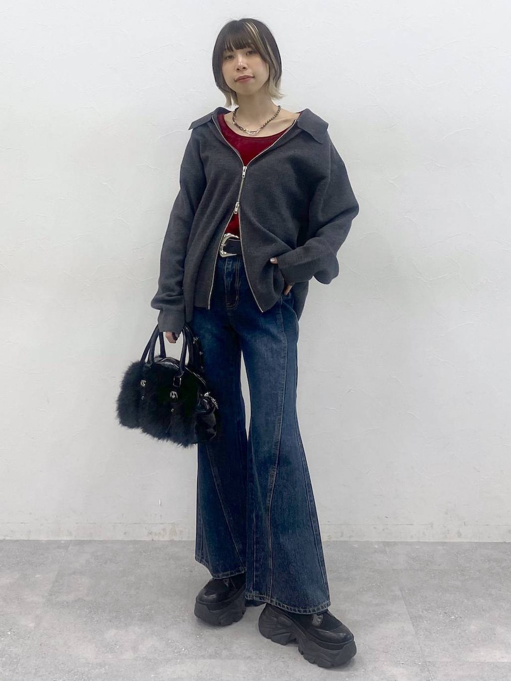 ブラック系のブーツ、ブルー系のデニムパンツ、レッド系のTシャツ/カットソーを着用したレディースの秋コーディネートの3枚目の写真