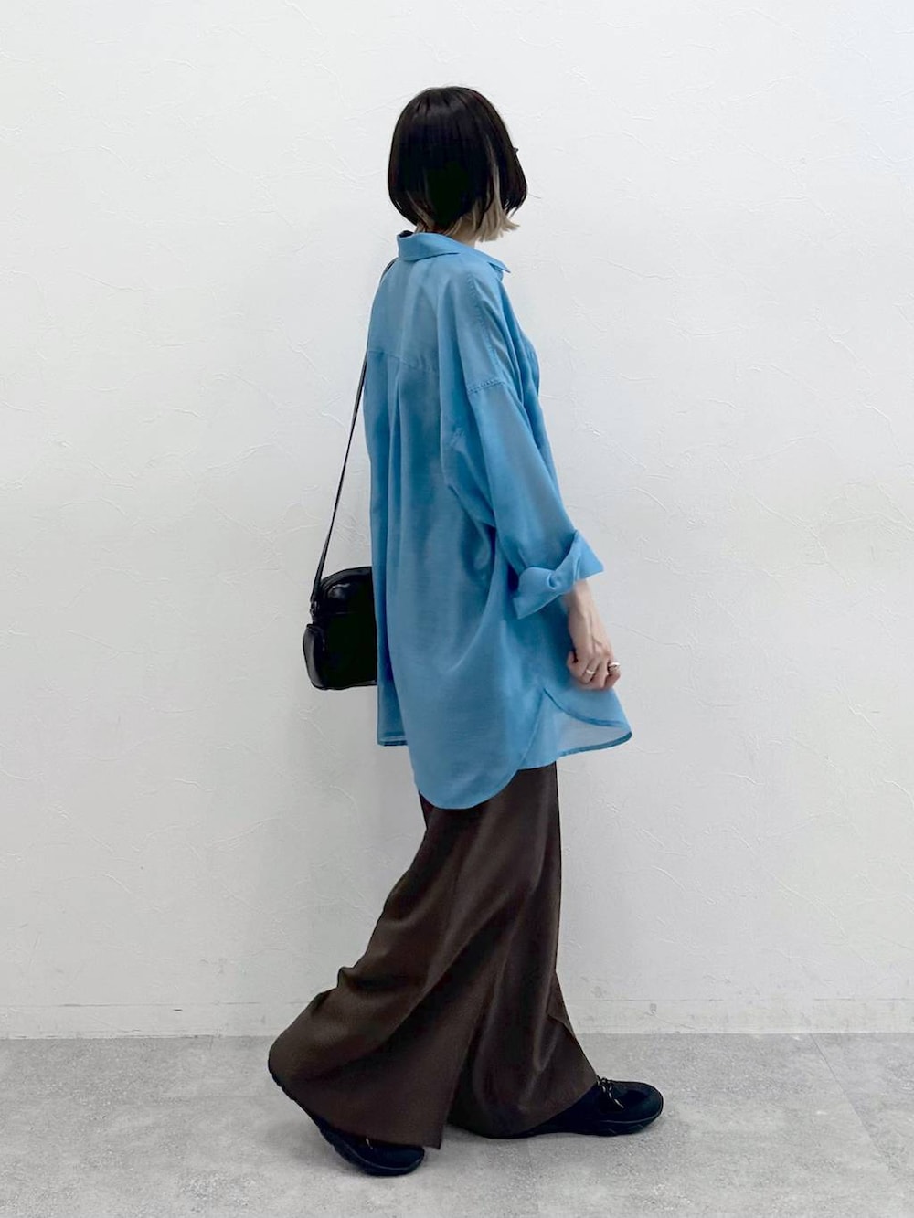 ブラック系のキャミソール、ブラック系のスニーカー、ブラック系のショルダーバッグを着用したレディースの春コーディネートの8枚目の写真