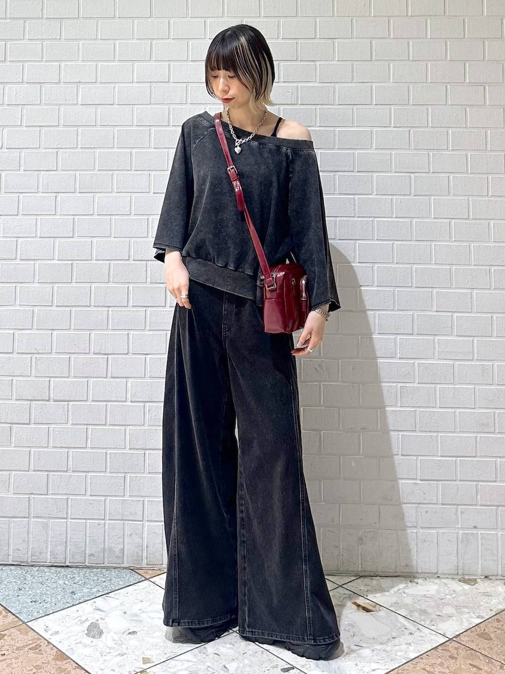ブラック系のデニムパンツ、ブラック系のTシャツ/カットソー、レッド系のショルダーバッグを着用したレディースの夏コーディネートの4枚目の写真