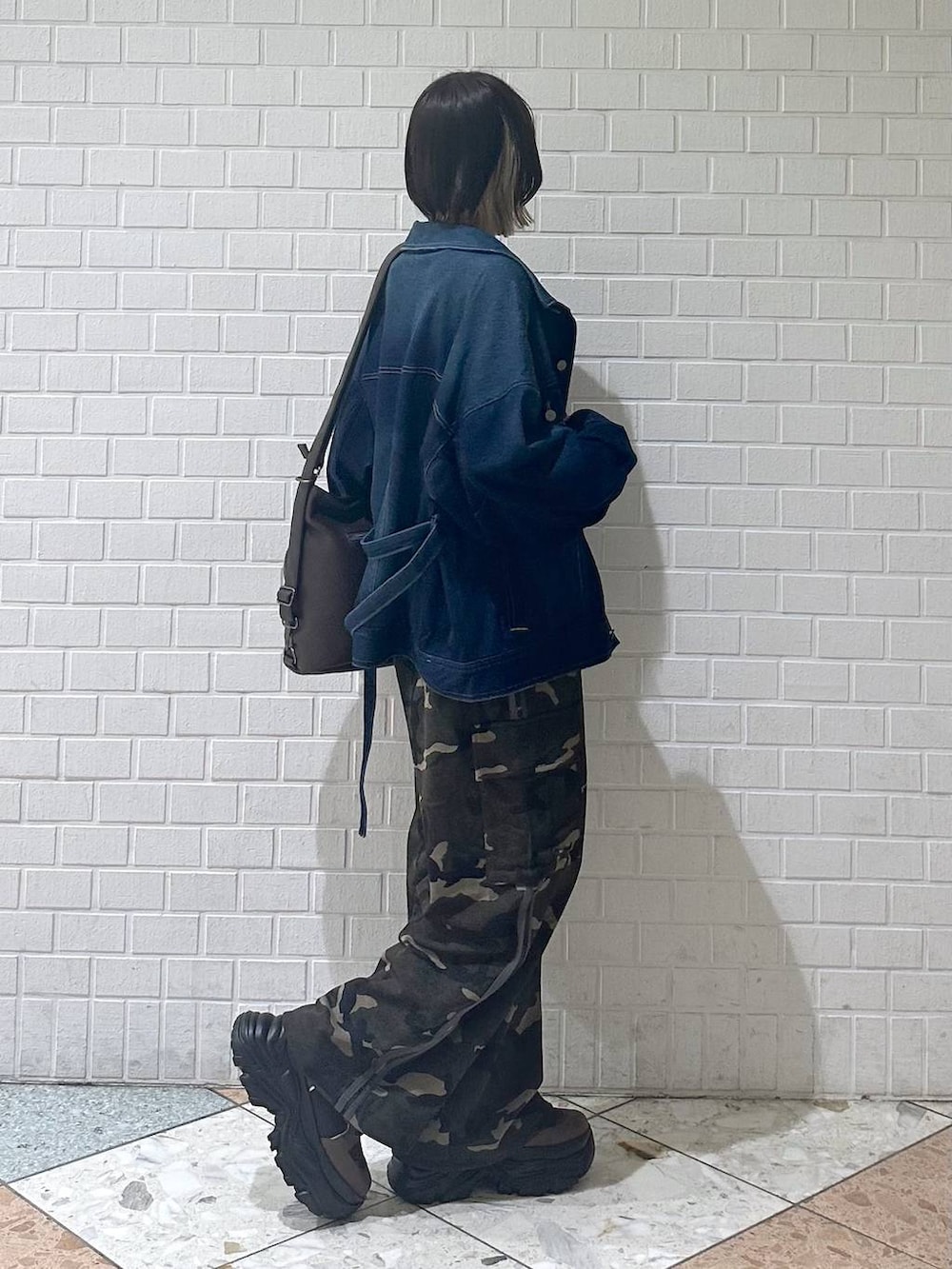 ブラウン系のブーツ、ブラック系のキャミソール、ブルー系のブルゾンを着用したレディースの春コーディネートの8枚目の写真