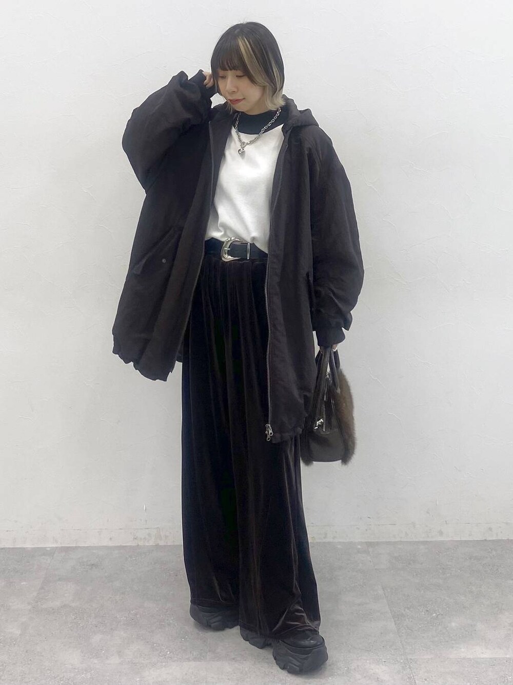 ブラック系のブーツ、ホワイト系のニット/セーター、ブラウン系のブルゾンを着用したレディースの秋コーディネートの8枚目の写真