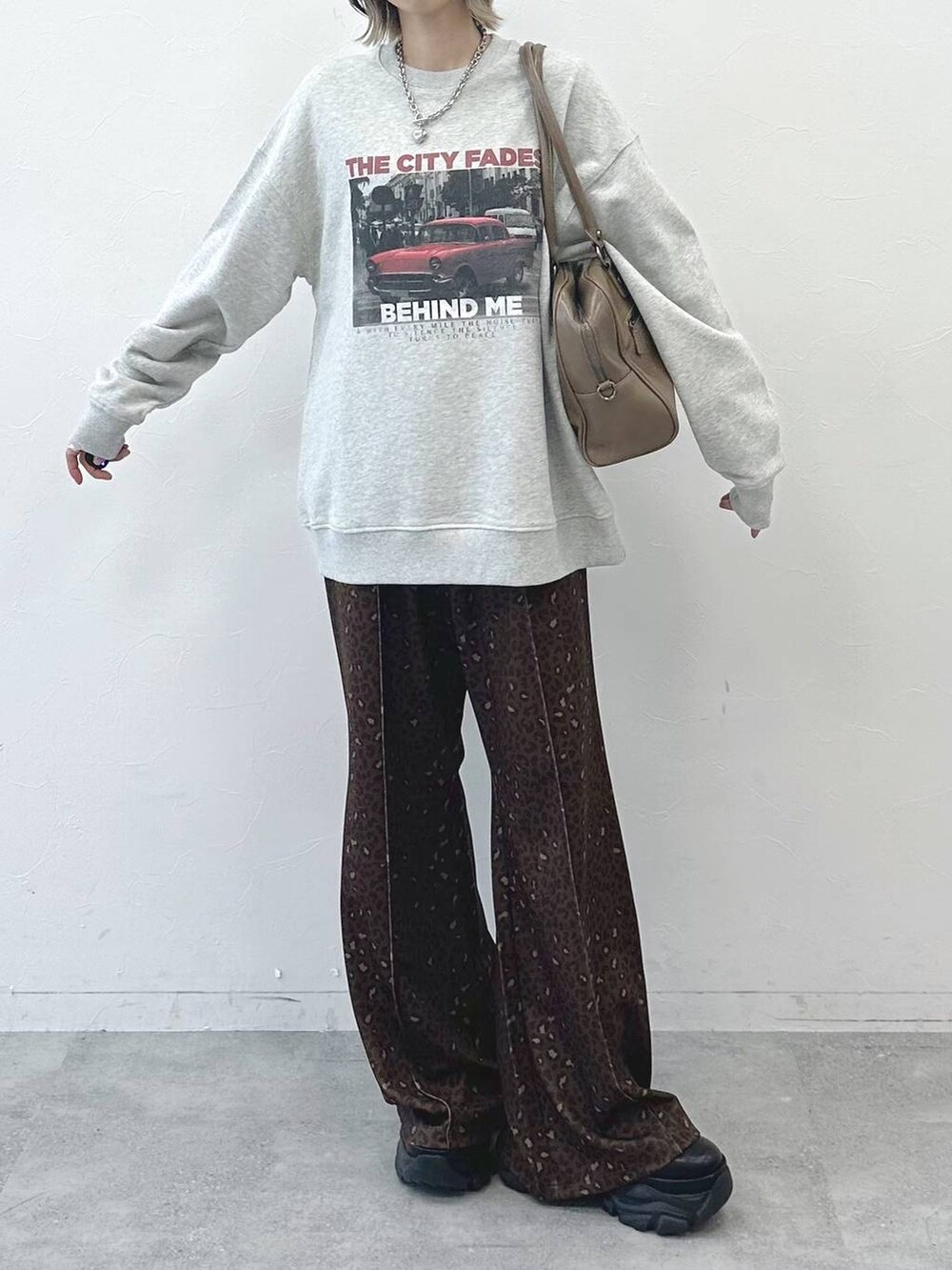 ブラック系のブーツ、ベージュ系のボストンバッグ、グレー系のスウェットを着用したレディースの冬コーディネートの4枚目の写真