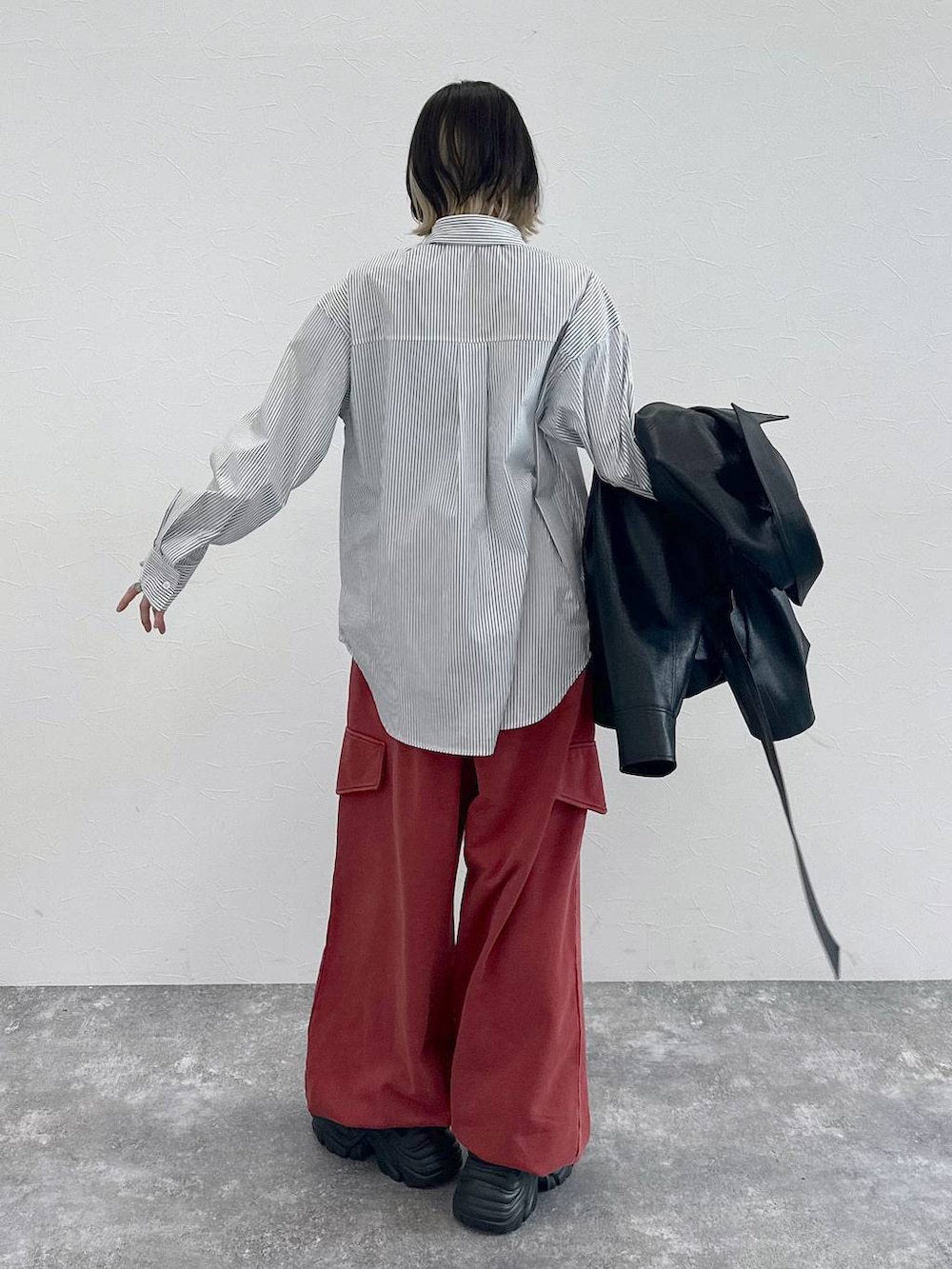 ブラック系のスニーカー、グレー系のシャツ/ブラウス、レッド系のその他パンツを着用したレディースの春コーディネートの6枚目の写真