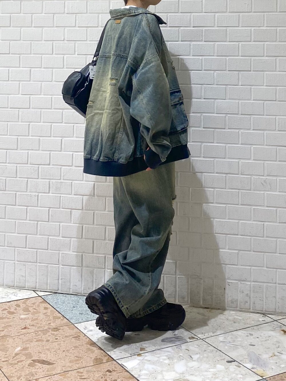 ブラック系のブーツ、ブルー系のデニムパンツ、ホワイト系のTシャツ/カットソーを着用したレディースの秋コーディネートの6枚目の写真