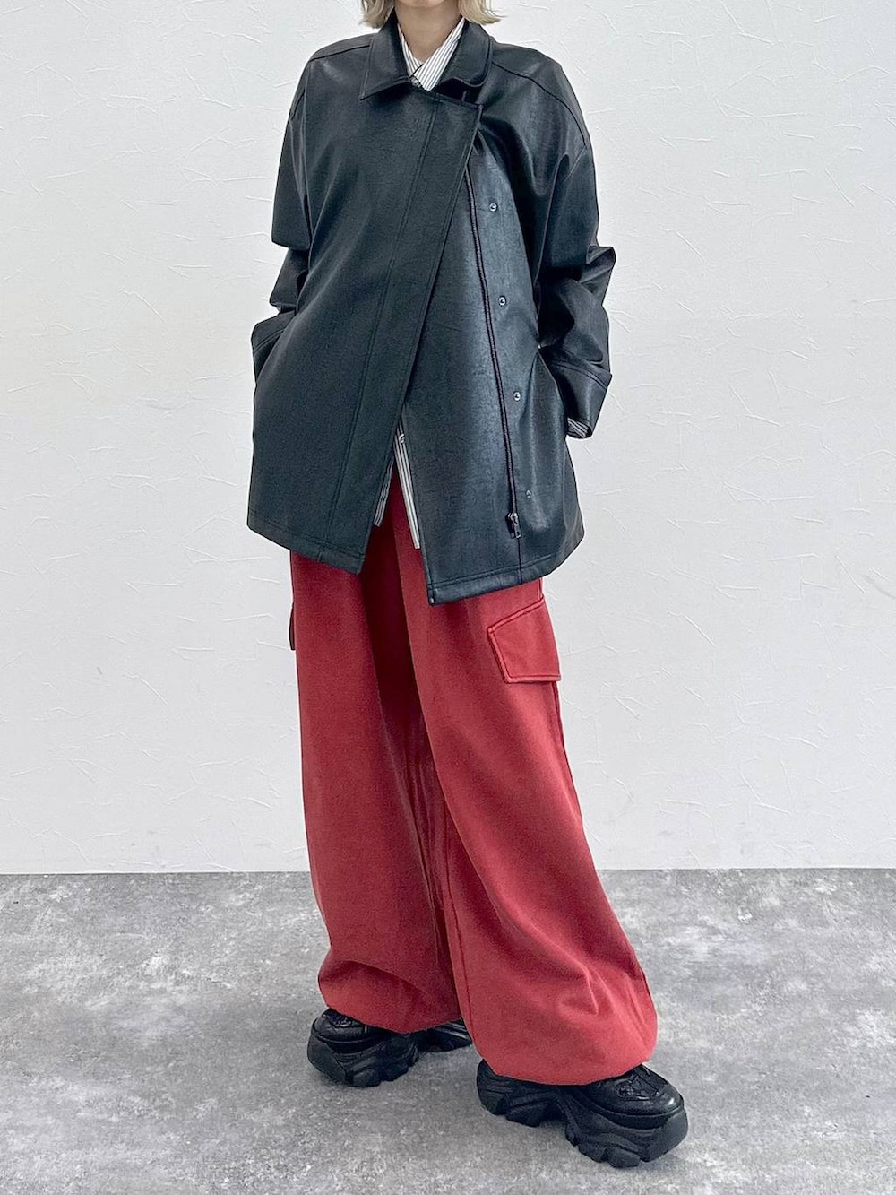 ブラック系のスニーカー、グレー系のシャツ/ブラウス、レッド系のその他パンツを着用したレディースの春コーディネートの3枚目の写真