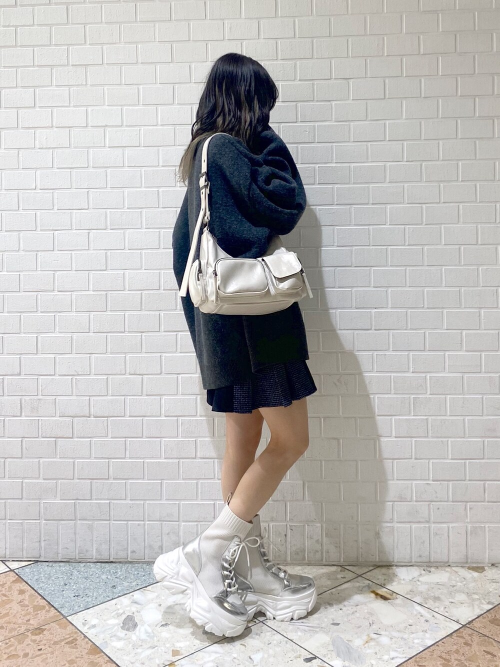 ホワイト系のブーツ、ホワイト系のショルダーバッグ、ブラック系のその他パンツを着用したレディースの秋コーディネートの2枚目の写真