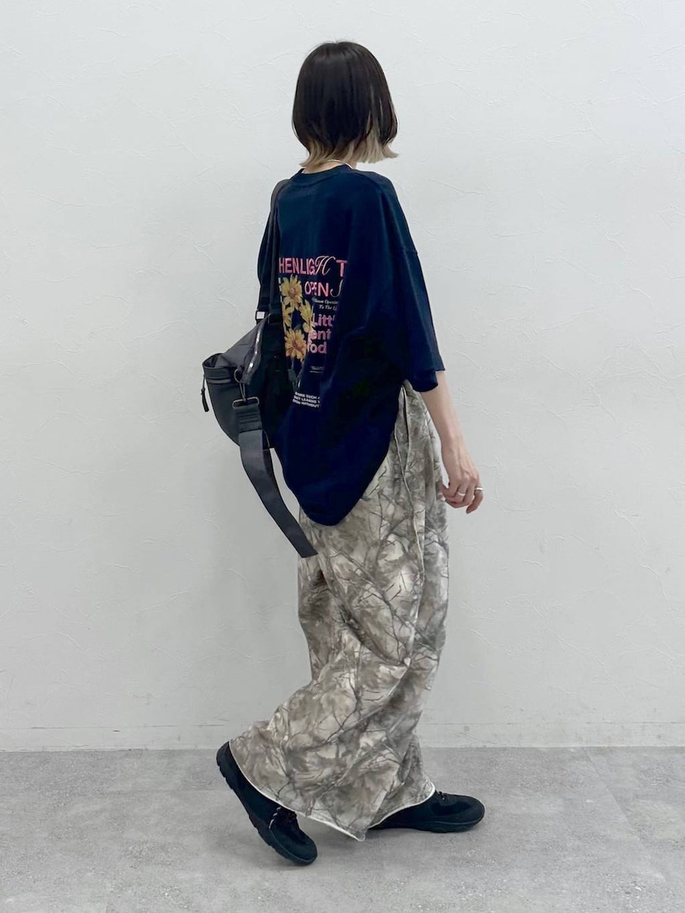 グレー系のボストンバッグ、ブラック系のスニーカー、ブルー系のTシャツ/カットソーを着用したレディースの夏コーディネートの6枚目の写真