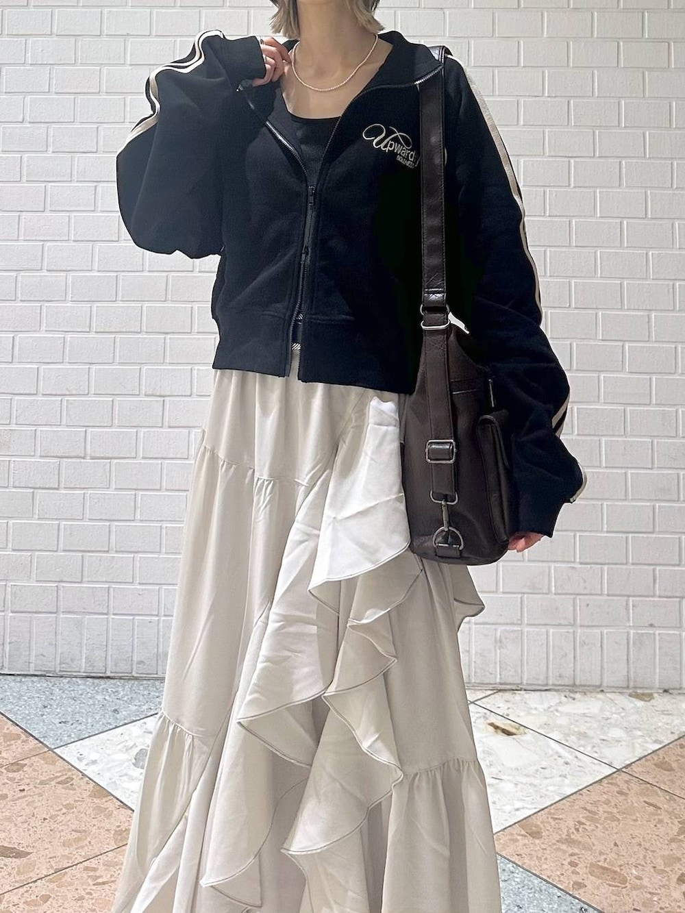 ブラウン系のブーツ、ブラック系のキャミソール、ベージュ系のスカートを着用したレディースの春コーディネートの9枚目の写真