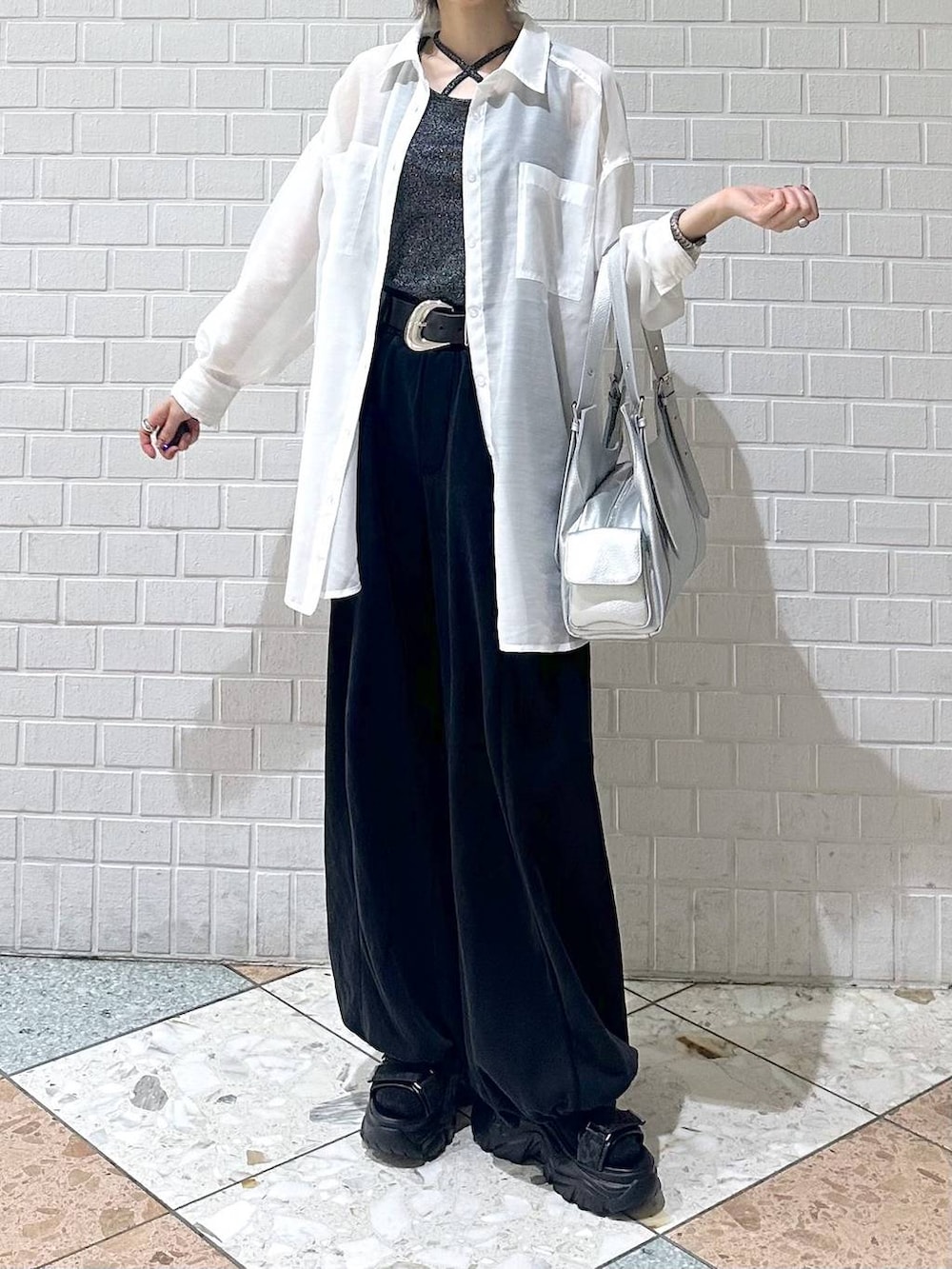 ブラック系のスウェットパンツ、ブラック系のサンダル、ホワイト系のシャツ/ブラウスを着用したレディースの春コーディネートの3枚目の写真