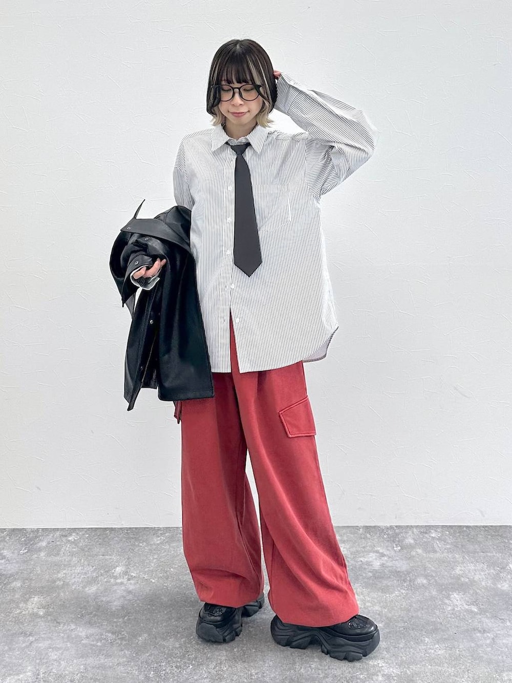 ブラック系のスニーカー、グレー系のシャツ/ブラウス、レッド系のその他パンツを着用したレディースの春コーディネートの2枚目の写真