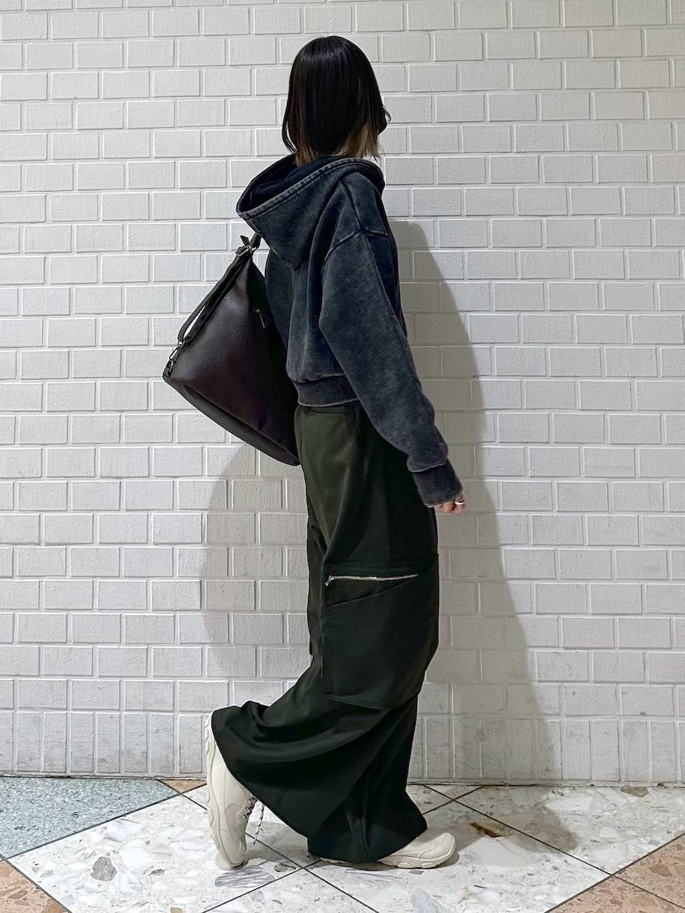 ブラック系のキャミソール、グレー系のパーカー、ホワイト系のスニーカーを着用したレディースの冬コーディネートの7枚目の写真