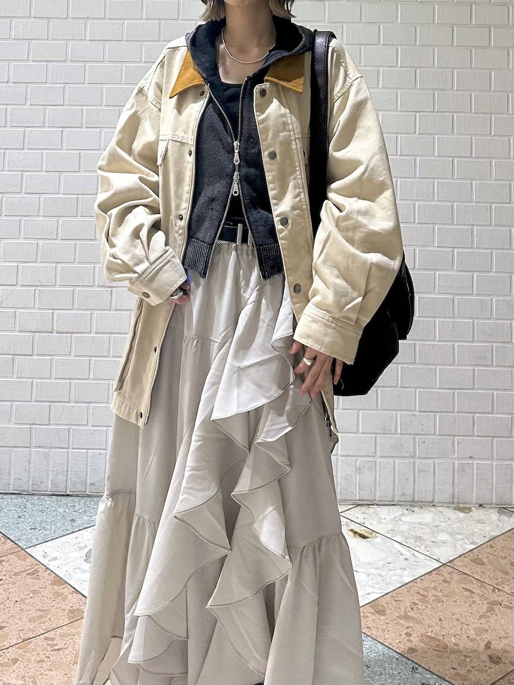 ブラウン系のブーツ、ブラック系のキャミソール、ベージュ系のスカートを着用したレディースの春コーディネートの8枚目の写真