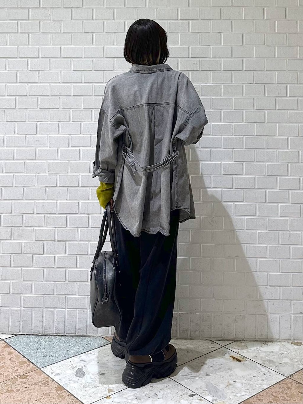 ブラウン系のブーツ、ブラック系のボストンバッグ、ブラック系のシャツ/ブラウスを着用したレディースの冬コーディネートの6枚目の写真