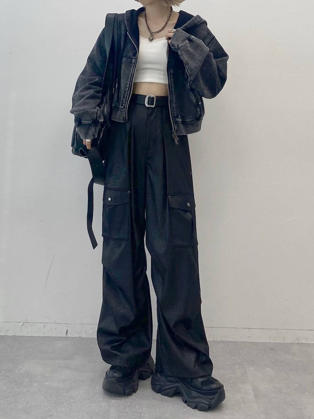 ブラック系のスニーカー、ホワイト系のキャミソール、ブラック系のカーゴパンツを着用したレディースの夏コーディネートの3枚目の写真