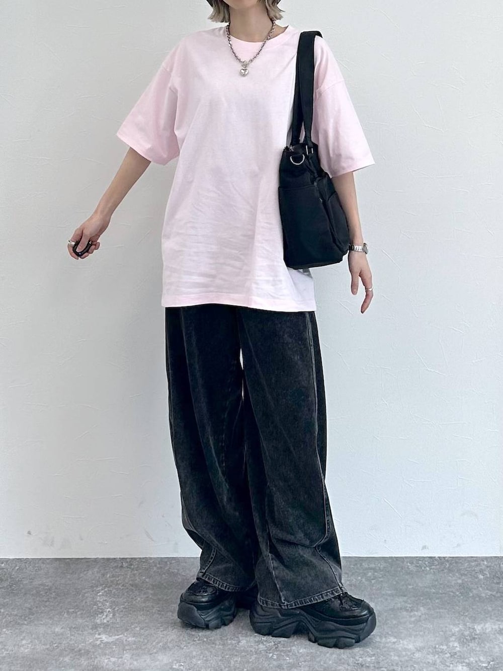 ブラック系のスニーカー、ブラック系のボストンバッグ、ブラック系のデニムパンツを着用したレディースの春コーディネートの4枚目の写真