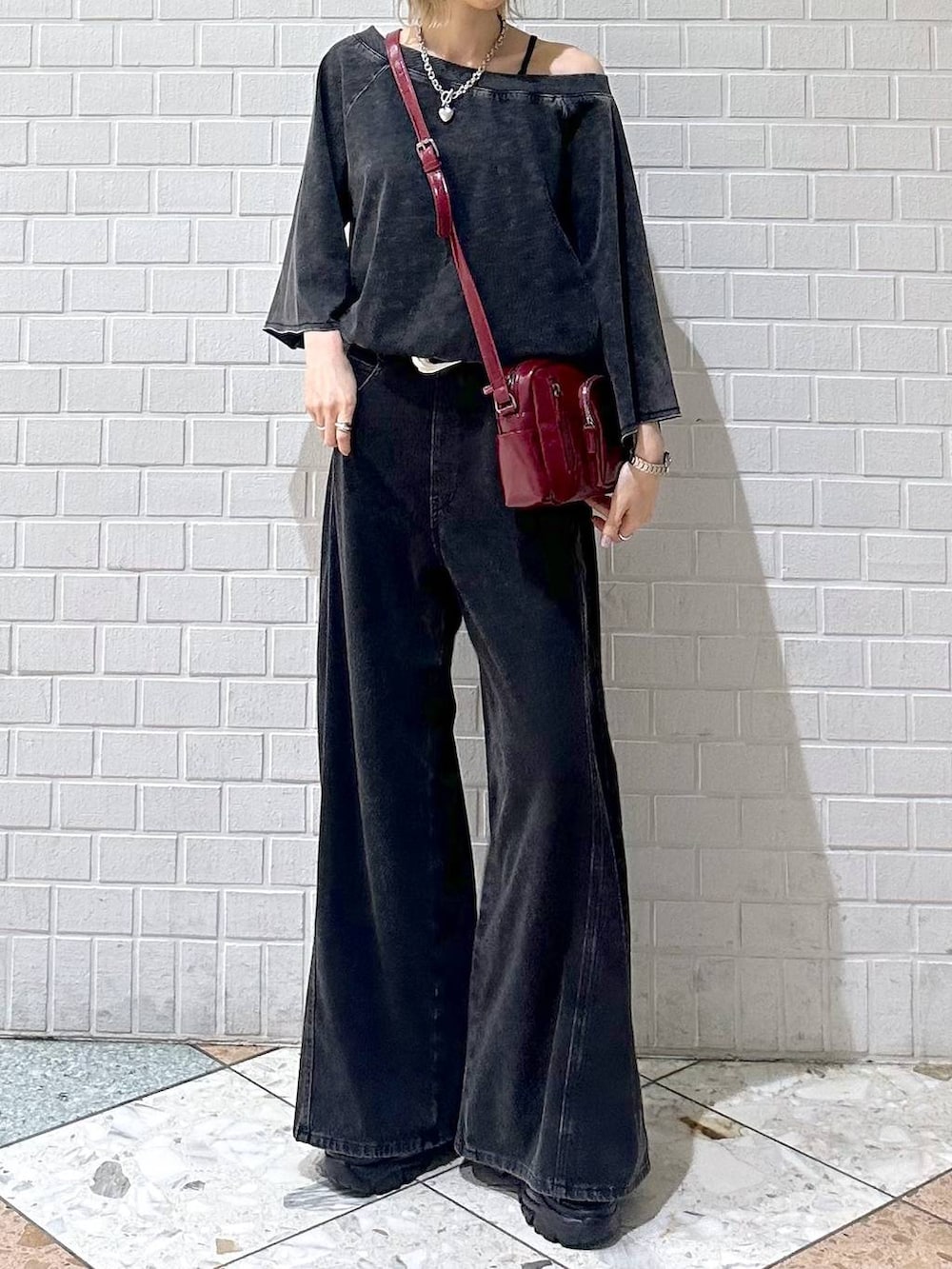 ブラック系のデニムパンツ、ブラック系のTシャツ/カットソー、レッド系のショルダーバッグを着用したレディースの夏コーディネートの2枚目の写真