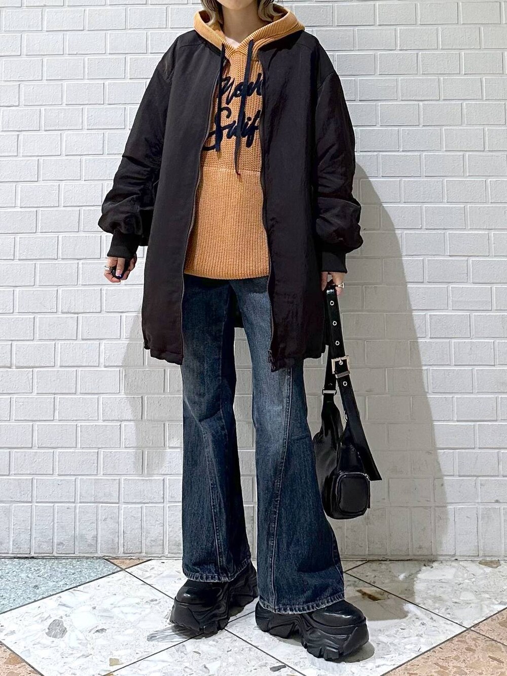 ブラック系のブーツ、ブルー系のデニムパンツ、ブラウン系のブルゾンを着用したレディースの秋コーディネートの3枚目の写真