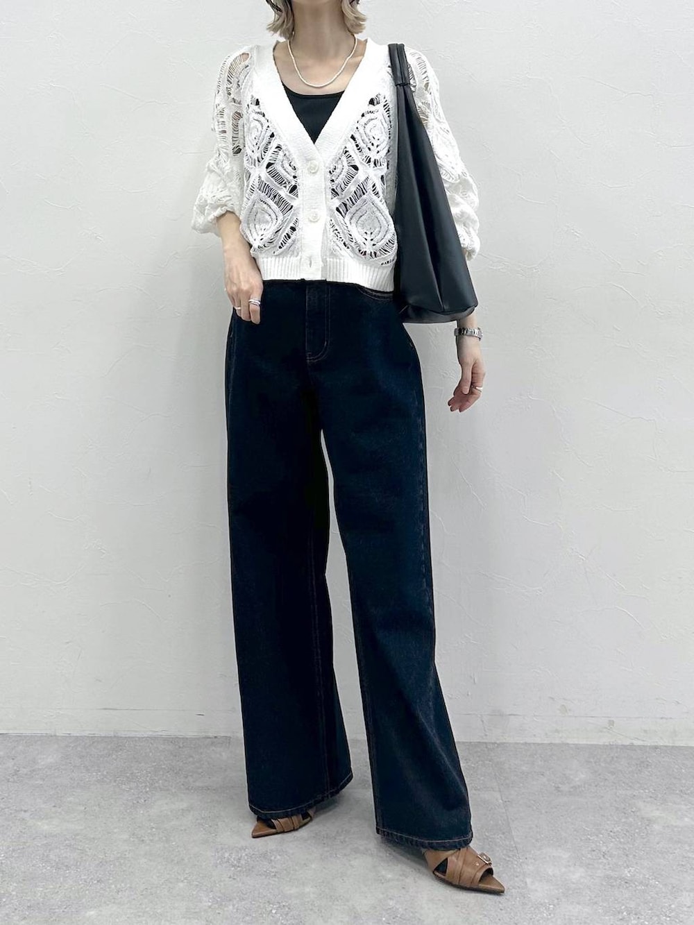 ブラック系のキャミソール、ホワイト系のカーディガン/ボレロ、ブルー系のスラックスを着用したレディースの春コーディネートの9枚目の写真