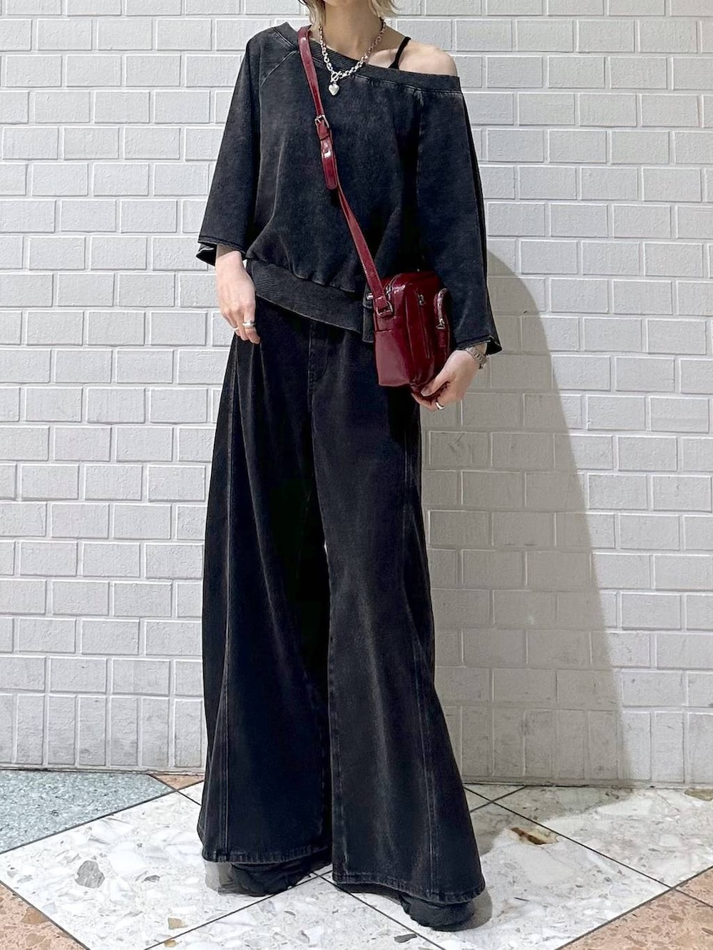 ブラック系のデニムパンツ、ブラック系のTシャツ/カットソー、レッド系のショルダーバッグを着用したレディースの夏コーディネートの9枚目の写真